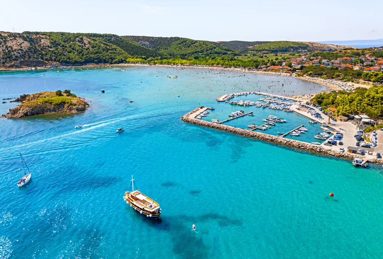 Charter catamaran underway in Croatian channel with crew at helm