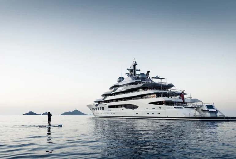 Superyacht swim platform with paddleboards and water toys deployed for guests