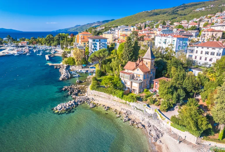 Aerial of a quiet coastal town with a small marina in soft light