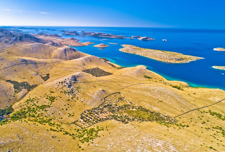 Aerial of stark Kornati hills with drystone walls, olive groves and turquoise bays