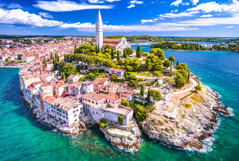 Aerial of the Rovinj headland with the St Euphemia bell tower and pastel houses