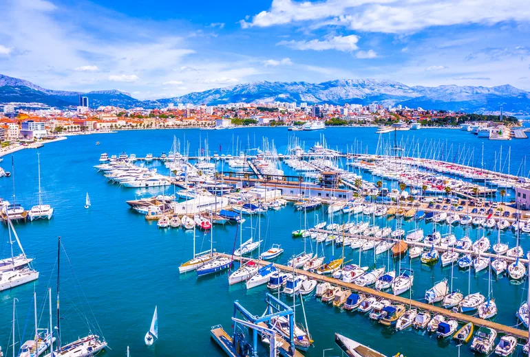 City marina packed with sailboats and mountains rising behind, central Dalmatia