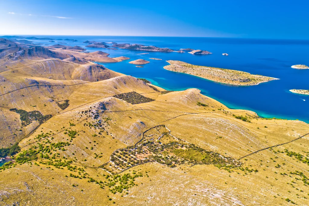 Aerial of stark Kornati hills with drystone walls, olive groves and turquoise bays